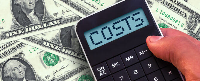 Calculator with the word Costs on the display and banknotes background